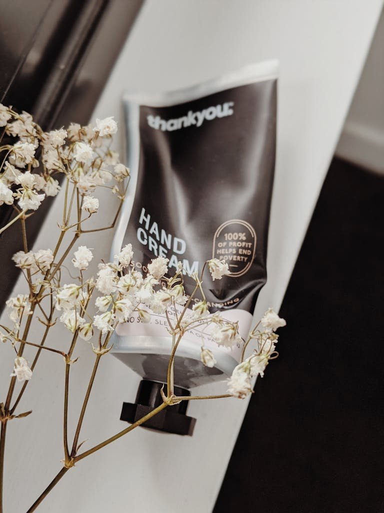 Aesthetic hand cream tube with dried flowers for a serene skincare vibe.